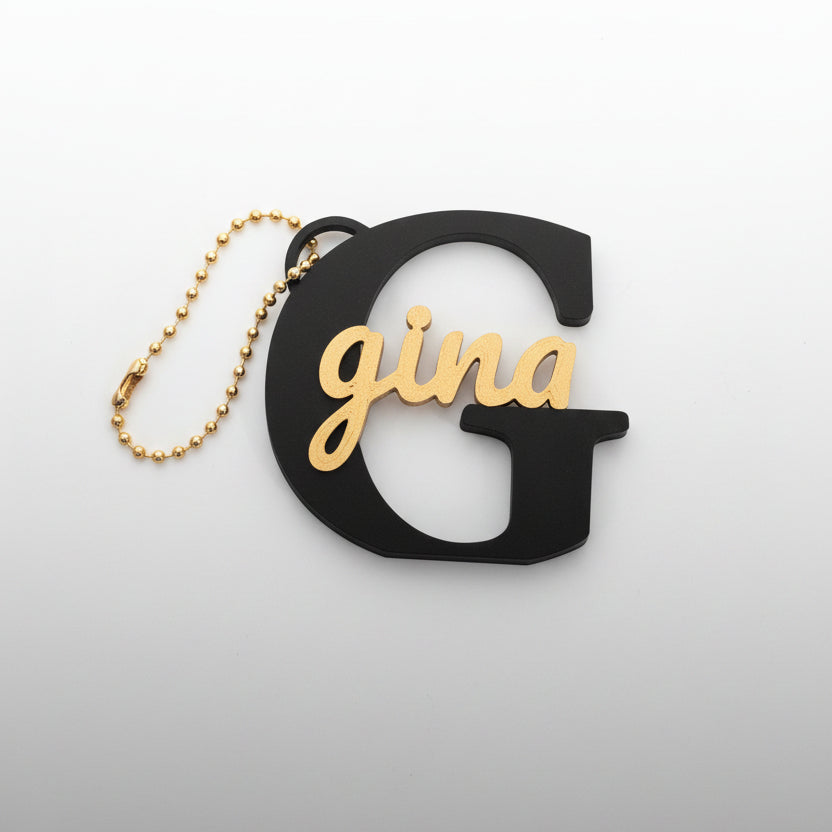 Personalized sign keychain close-up showing custom name engraving in black and gold