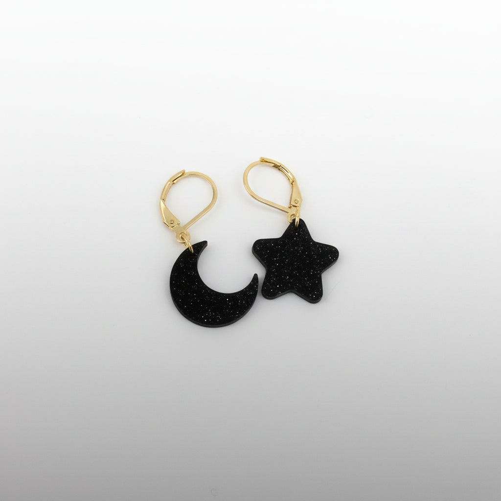 Black moon and star earrings on a white background