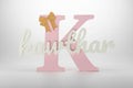 Decorative letter 'K' with a gold bow on a white background