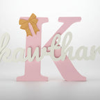 Decorative letter 'K' with a gold bow on a white background