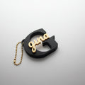 Personalized sign keychain close-up showing custom name engraving in black and gold