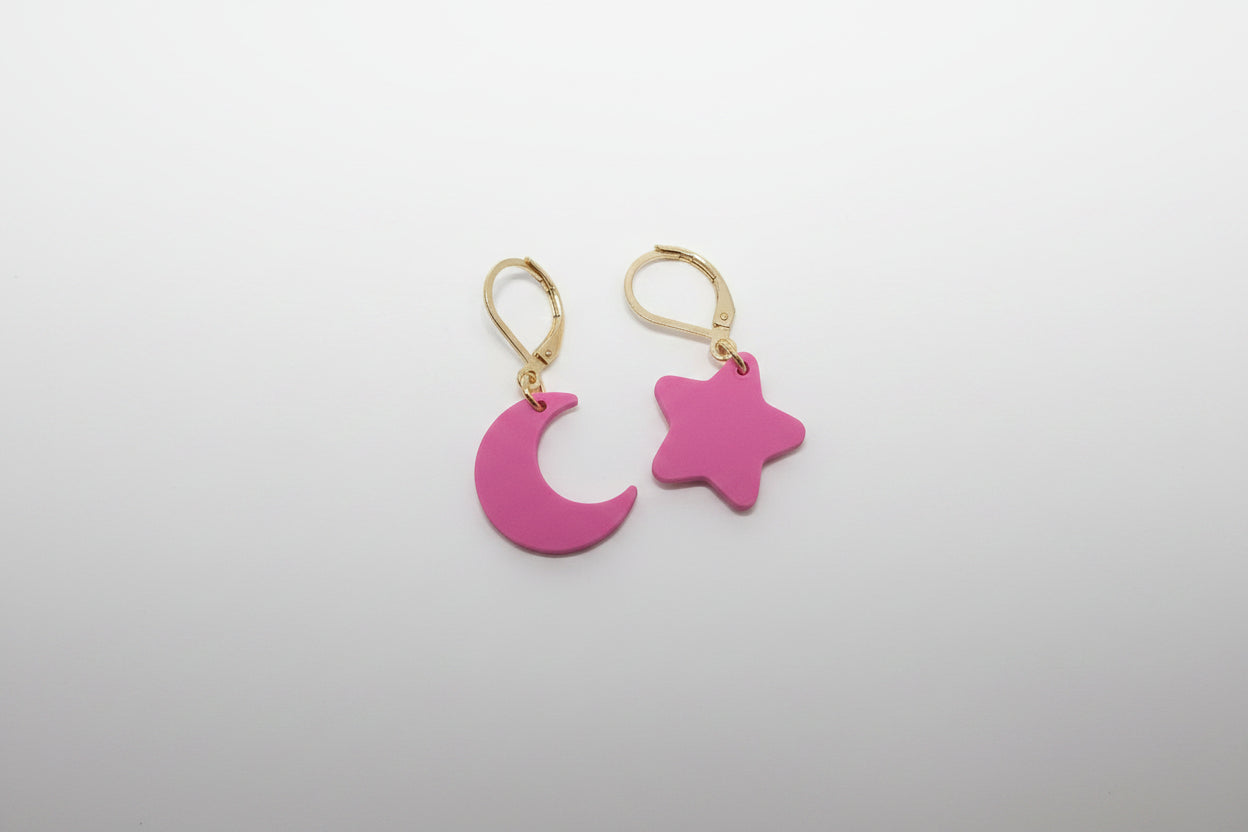 Pink moon and star earrings on a light gray background