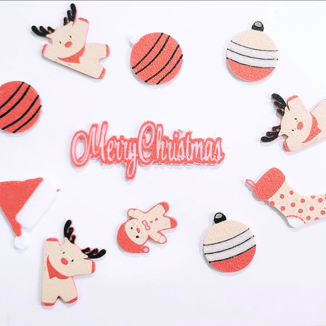 Custom 3D printed pieces by Aurelis Design Studio of Christmas-themed decorative items such as reindeer, ornaments, santa's hat, gingerbread man with 'Merry Christmas' text on a white background