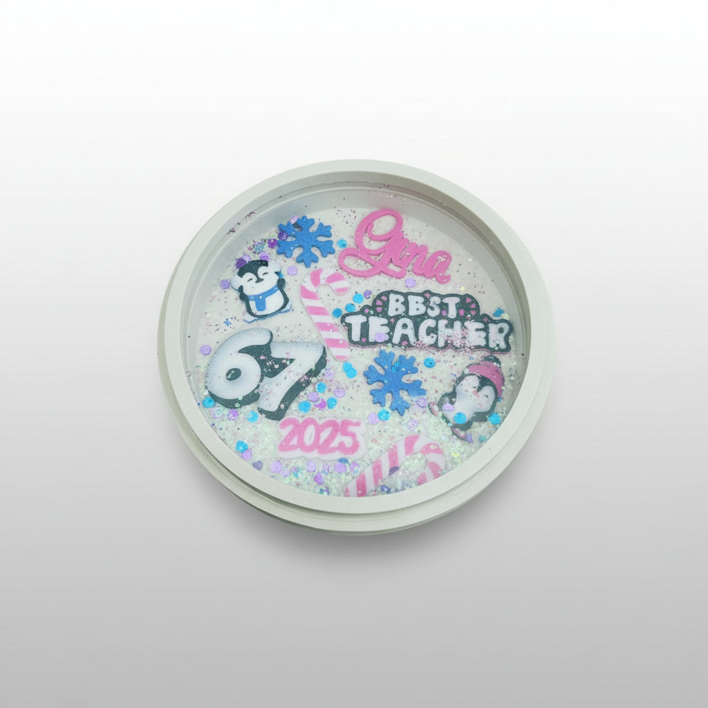 Decorative lid with 'Best Teacher 2025' text and cute 3d printed characters on a white background by Aureiis Design Studio