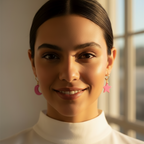 Woman wearing pink earrings with a blurred background