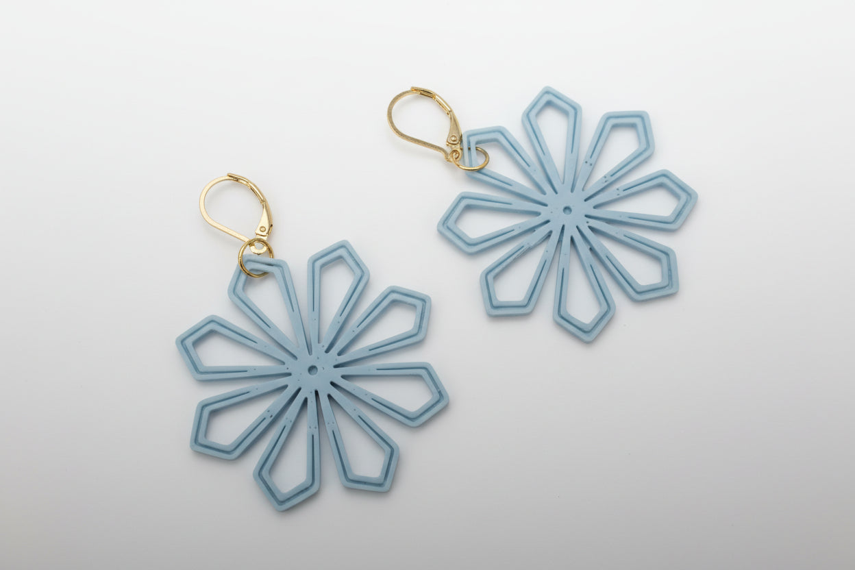Geometric Flower Earrings styled flat lay — lightweight statement jewelry in light blue by Aurelis Design Studio
