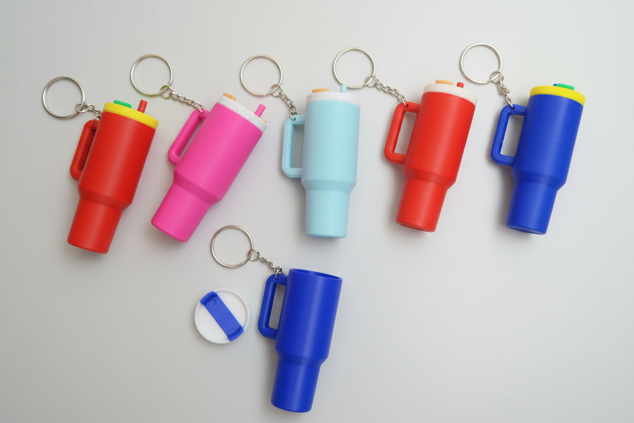 Colorful keychains shaped like stanley cups on a white background